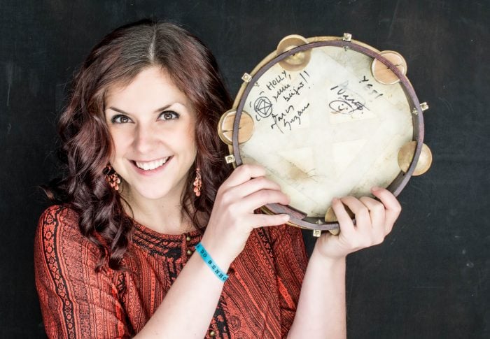 holly prest, artistic director, holding a pandeiro drum