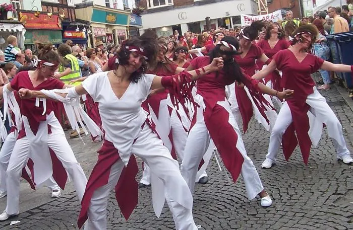 Group of dancers performing in the streets with a crowd watching