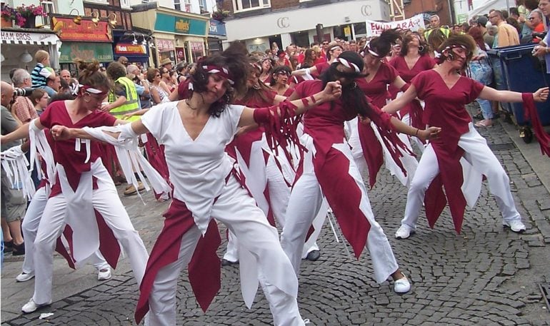 Group of dancers performing in the streets with a crowd watching