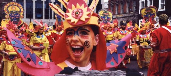 Facepainted Carnival performer smiling close up to the camera