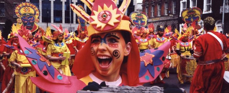 Facepainted Carnival performer smiling close up to the camera