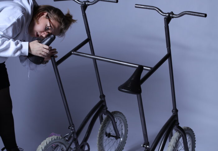 Woman with two bikes welded together