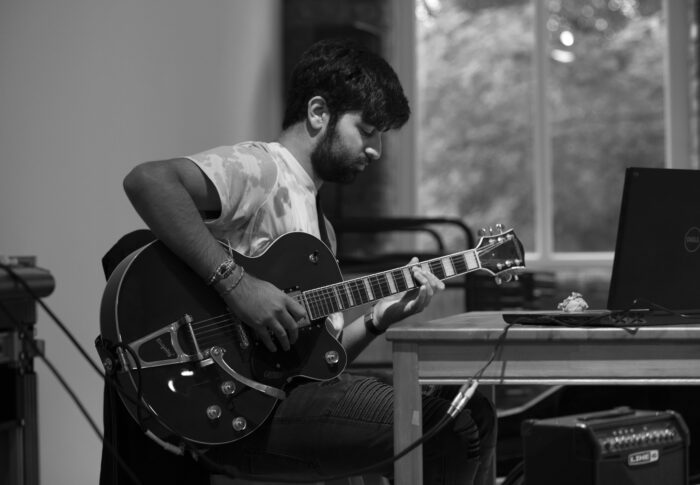 guitarist making music at a laptop