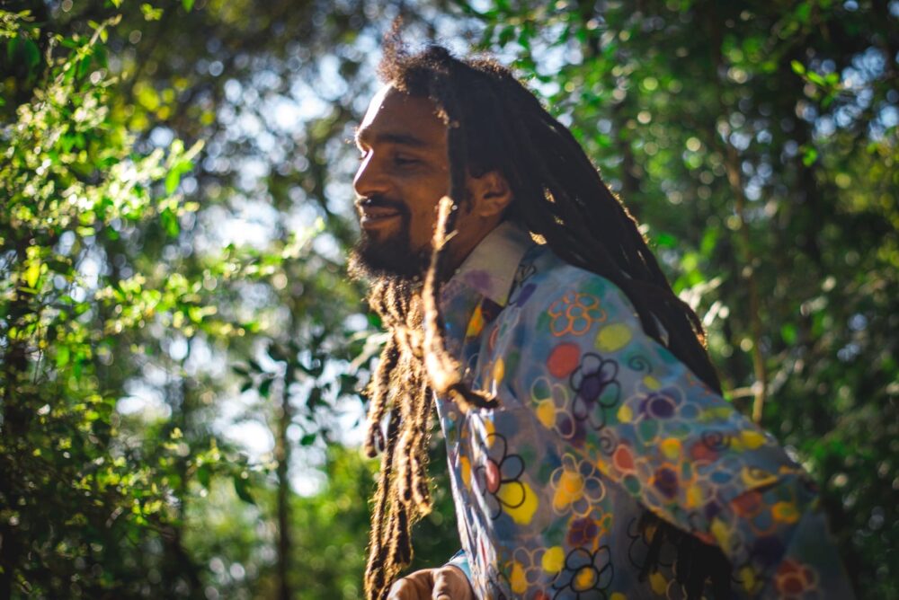 Guga, Brazilian percussionist, smiling in the sunshine is the forest